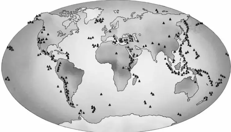 Mapamundi en proyección elíptica con triángulos negros que señalan volcanes; se concentran en el oeste de América, el arco occidental del Pacífico, el Mediterráneo, África oriental y las dorsales oceánicas.