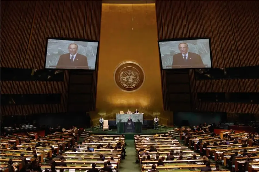 Fotografía de la sala de la Asamblea General de la ONU, con delegados sentados, pantallas que muestran a un orador y el emblema de la organización al fondo.
