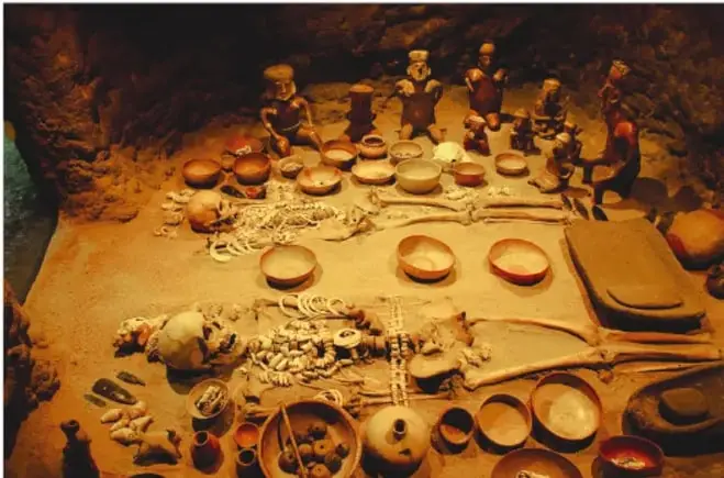 Diorama de un campamento de cazadores-recolectores con utensilios, vasijas y restos de animales.
