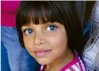 Rostro de una niña de ojos claros muy de cerca, primerísimo primer plano.