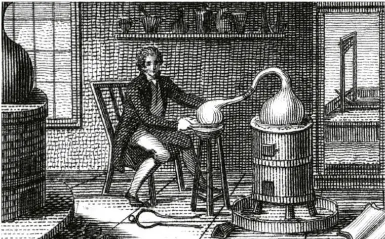Grabado antiguo que muestra a Antoine Lavoisier trabajando en su laboratorio: sentado junto a una mesa, sostiene un recipiente esférico conectado a una retorta colocada sobre un hornillo. Al fondo se observan estantes con frascos y una ventana.