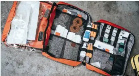 Mochila de emergencia abierta con suministros médicos y de primeros auxilios.