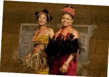 Dos mujeres con vestimenta tradicional afrodescendiente, sonriendo.