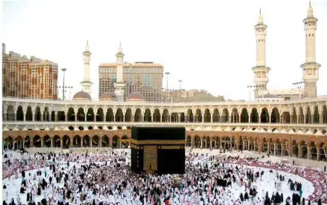 Fotografía aérea de la Gran Mezquita de La Meca con la Kaaba en el centro, rodeada de peregrinos y de minaretes.
