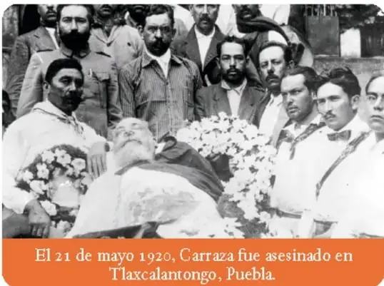 Fotografía en blanco y negro de un grupo de hombres, algunos con sombrero, alrededor de un ataúd. Al pie se lee: 'El 21 de mayo de 1920, Carranza fue asesinado en Tlaxcalantongo, Puebla'.