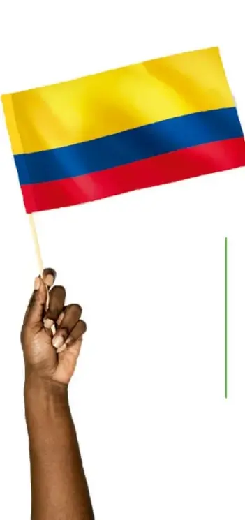 Fotografía de una mano que sostiene una bandera colombiana en un palito, sobre fondo blanco.
