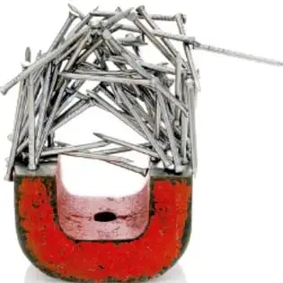 Imán en forma de herradura de color rojo con varios clavos de metal pegados en sus polos, mostrando la atracción magnética.