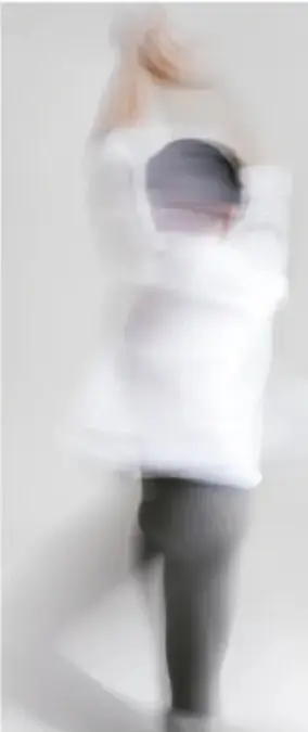 Persona con ropa blanca y brazos levantados, en movimiento ascendente, fondo claro.