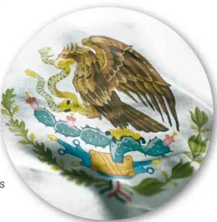 Fotografía del Escudo Nacional bordado sobre una bandera: águila con serpiente sobre nopal, con ramas de encino y laurel.