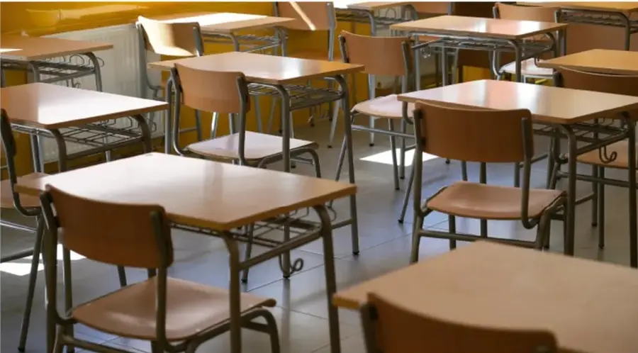 Fotografía de un aula escolar con bancas metálicas de paleta de madera, correspondientes al ejemplo de bancas a reparar.