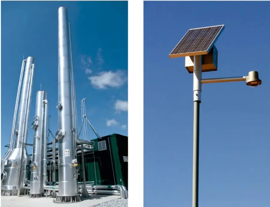 Fotografía de una planta de procesamiento energético con varias torres metálicas cilíndricas altas, tuberías y estructuras industriales bajo un cielo azul con nubes.