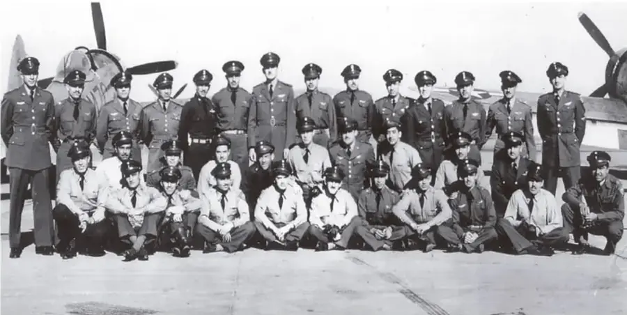 Fotografía en blanco y negro de un grupo numeroso de militares mexicanos, la mayoría de pie y algunos sentados o arrodillados, posando frente a un avión de la Fuerza Aérea Mexicana. Visten uniformes de gala y gorras. La imagen ilustra la formación del Escuadrón 201.