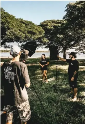 Equipo de estudiantes graba un video al aire libre con cámara y micrófono, como parte del material audiovisual del proyecto.
