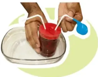 Frasco tapado con globo rojo dentro de una charola con agua.