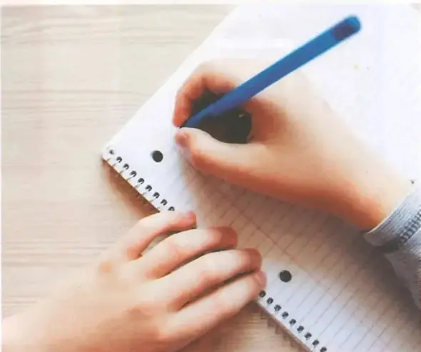 Fotografía de una persona escribiendo notas en un cuaderno, relacionada con la planificación y preparación de una exposición.