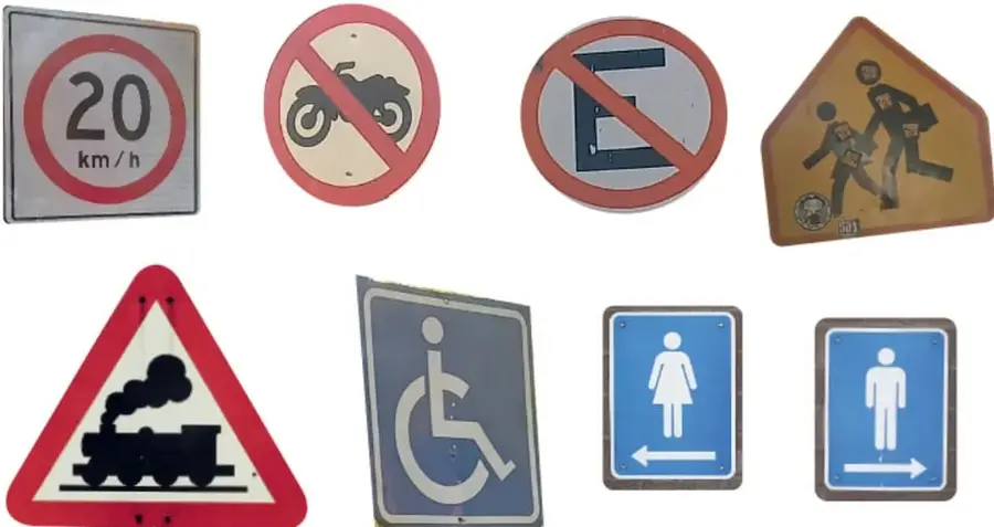 Cuatro señales: límite de velocidad 20 km/h, prohibido motocicletas, prohibido estacionarse y zona escolar.