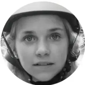 Fotografía en blanco y negro del rostro de una persona joven con casco, mirando de frente.