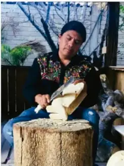 Persona tallando madera, con crédito 'Laura Fuentes, OAXACA'.