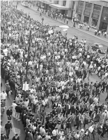 Fotografía en blanco y negro de una multitud marchando por una avenida, probablemente la marcha silenciosa del 13 de septiembre de 1968.