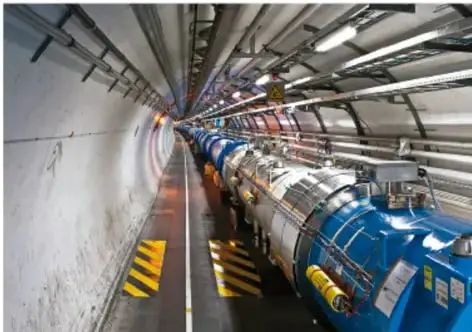 Fotografía del túnel del Gran Colisionador de Hadrones (LHC), con equipo azul y señalización amarilla y negra.