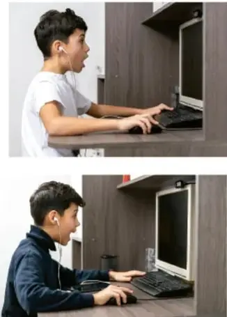 Niño con audífonos usando una computadora de escritorio.