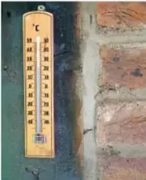 Termómetro colocado sobre una pared de ladrillo, relacionado con el clima.