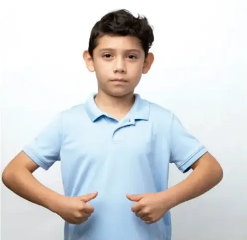 Fotografía de un niño con camisa azul que señala su pecho con ambas manos, como si se presentara o hablara de sí mismo.