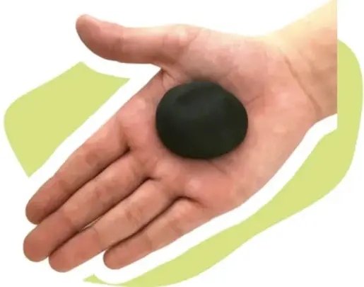 Mano presionando hacia abajo un cilindro negro de plastilina apoyado sobre una superficie.
