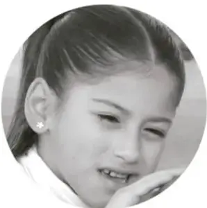 Fotografía de una niña sonriente con uniforme escolar.