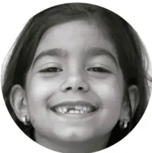 Fotografía de una niña sonriente con el cabello recogido.