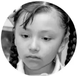 Fotografía de una niña con trenzas y uniforme escolar.