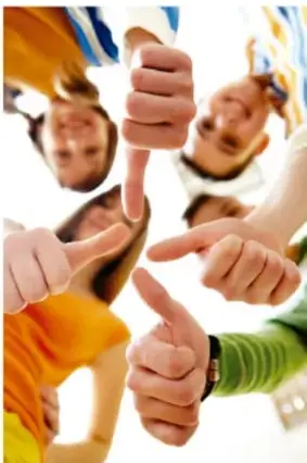 Fotografía de un grupo de jóvenes vistos desde abajo, con los pulgares arriba en señal de aprobación, representando trabajo en equipo y acuerdo.