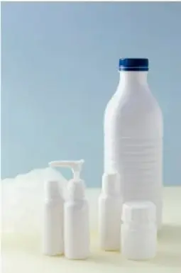 Fotografía de frascos y envases blancos de productos medicinales o cosméticos sobre fondo claro.