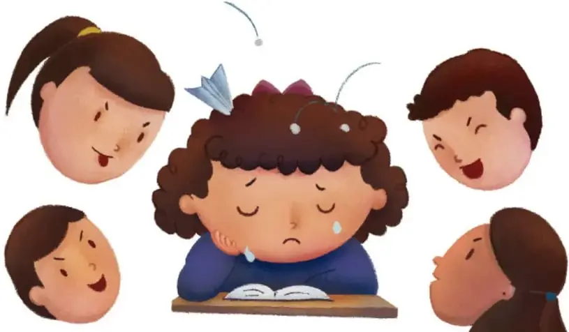 Ilustración de una niña de cabello rizado llorando con la cabeza apoyada sobre un libro, rodeada de cuatro rostros de compañeros con expresiones de burla; vuelan hacia ella una avioneta de papel y pequeñas bolitas.
