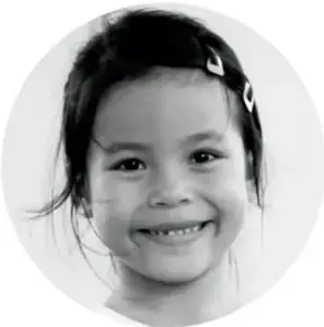 Retrato en blanco y negro de una niña sonriente con el cabello recogido.