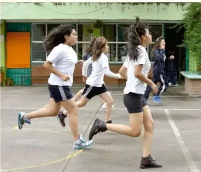Estudiantes corriendo en una pista atlética.