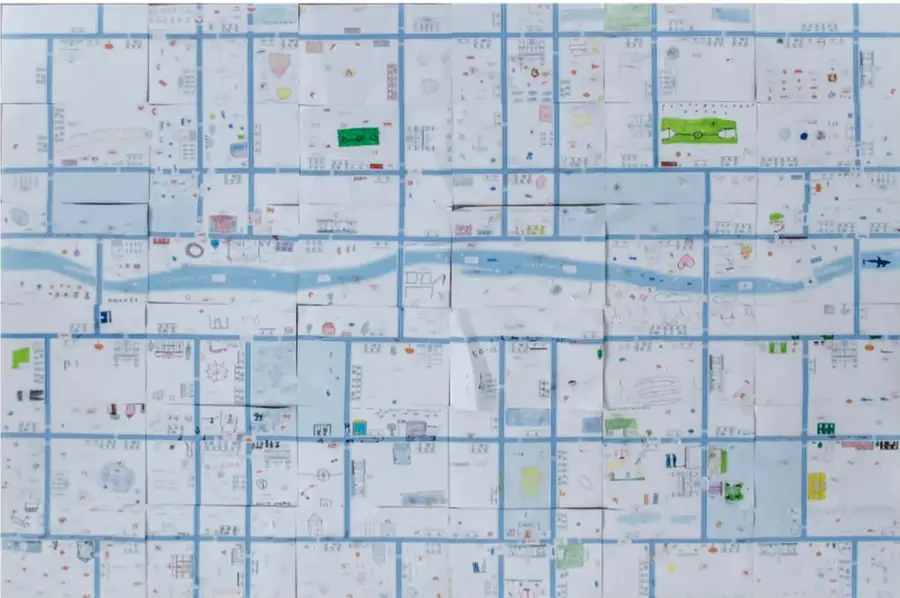 Mapa comunitario elaborado con hojas cuadriculadas que muestran calles, un río, casas, árboles y espacios verdes; representa el entorno donde se desplazan las personas y los animales.