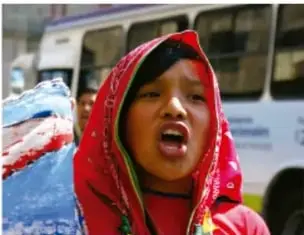 Mujer con rebozo rojo mostrando cara y hombros, primer plano.