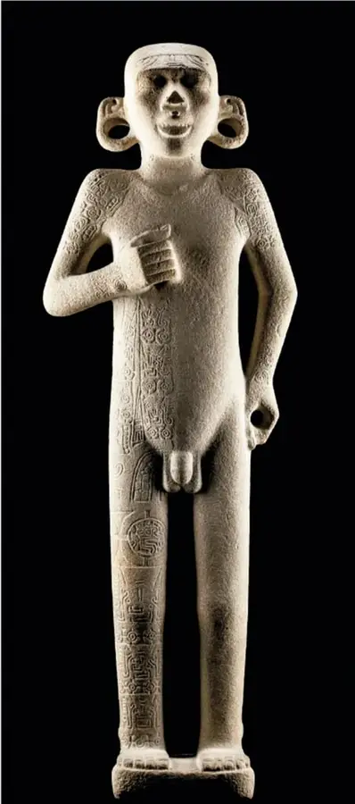 Escultura antigua de pie de un cuerpo humano con relieves y marcas en brazos, torso y piernas.