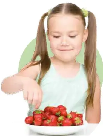 Niña con polera celeste sosteniendo un plato lleno de fresas.