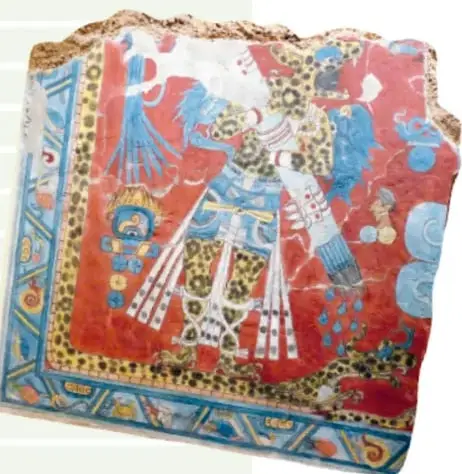 Fragmento de un mural prehispánico de colores rojo y azul que representa una figura con penacho y elementos simbólicos.