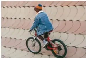 Ciclista con casco recorriendo una pared de ladrillo, ilustrando interacción en movimiento.