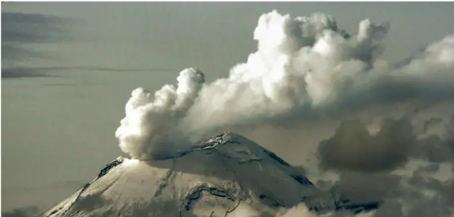 Volcán nevado con una gran columna de vapor y ceniza, ejemplo de fenómeno natural.