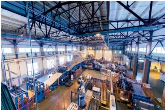 Fotografía del interior de una planta industrial con líneas de producción y maquinaria, que representa la industria manufacturera.
