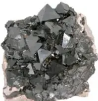 Fotografía de un fragmento de magnetita, mineral negro brillante de óxido de hierro.