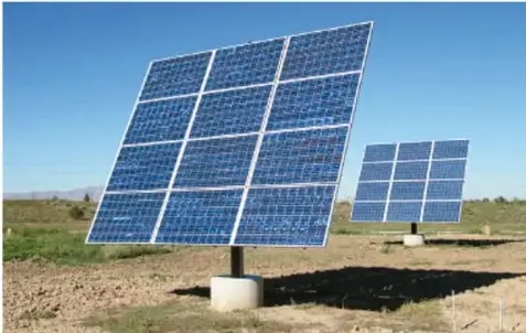 Fotografía de paneles fotovoltaicos instalados en un campo desértico bajo un cielo despejado.