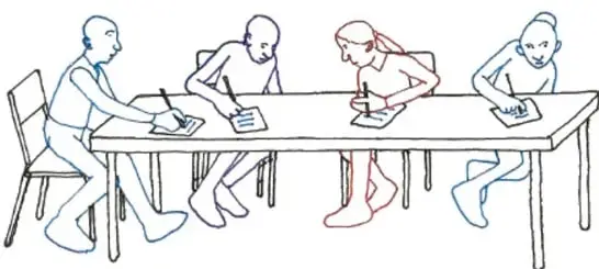 Cuatro estudiantes sentados en una mesa escribiendo y dialogando.