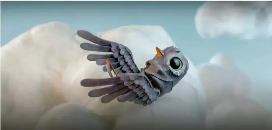 Fotograma del cortometraje: un pájaro gris con ojos grandes vuela entre nubes blancas sobre un cielo azul.