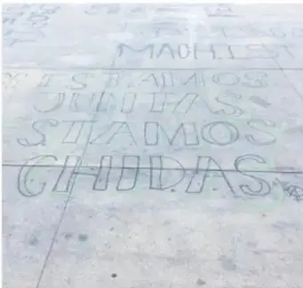 Fotografía de un pavimento con leyendas escritas (grafiti) que incluyen palabras como "MACHISTA", "QUEREMOS VIVIR SIN MIEDO", "CHIDAS", relacionada con la expresión lingüística juvenil en el espacio público.
