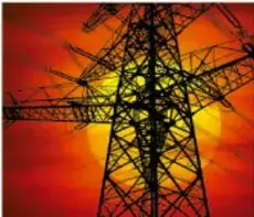Silueta de una torre de alta tensión eléctrica contra un cielo naranja y rojizo al atardecer, ilustrando la transmisión de energía eléctrica.